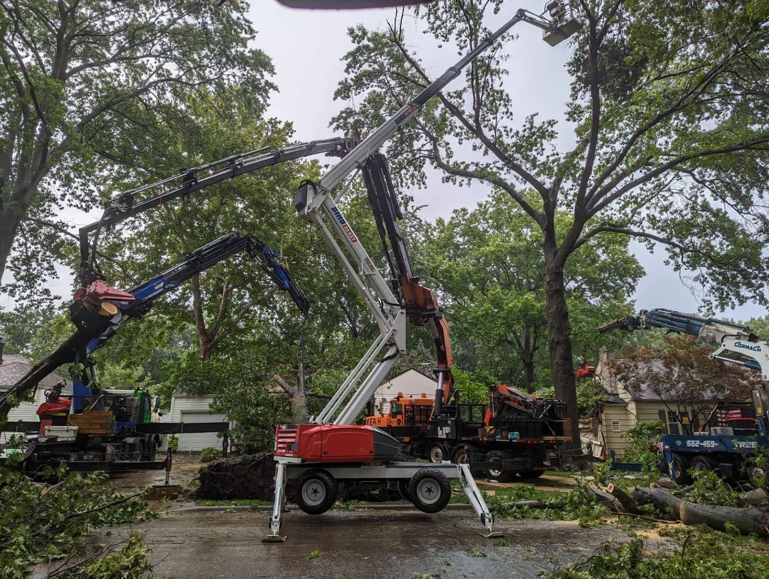 Spider lift and multiple grapple cranes working a storm damaged neighborhood